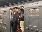 An MTA employee conversing with a passenger in the Arnine Car at 2nd Ave Station 